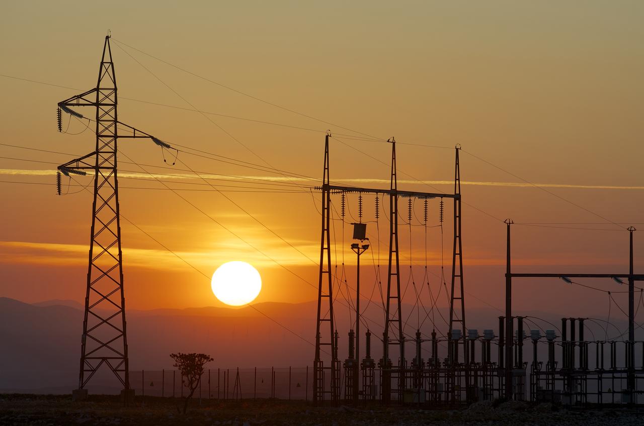 Transmission towers silhouetted against a Namibian sunset
